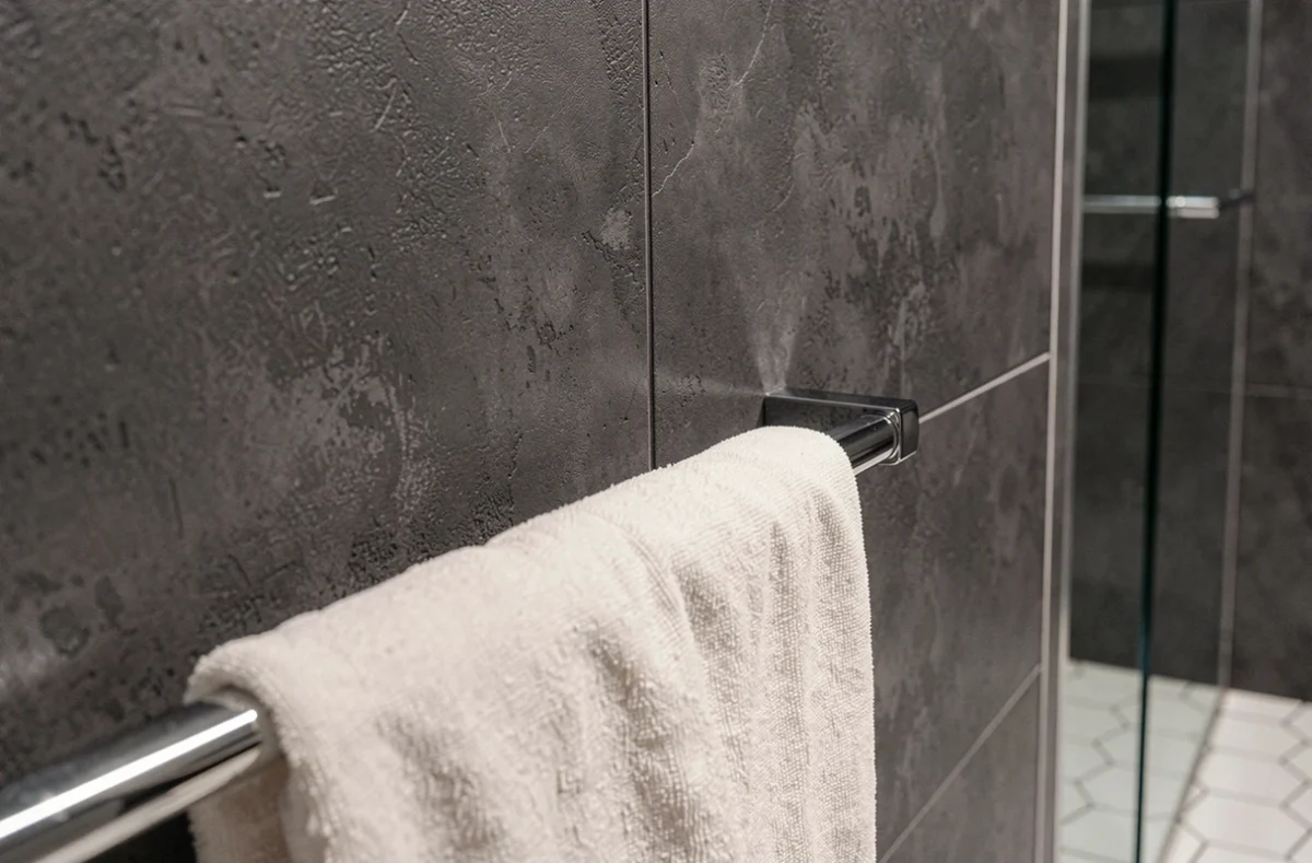 Détail de dalles murales PVC anthracite effet béton dans une salle de bain contemporaine haut de gamme